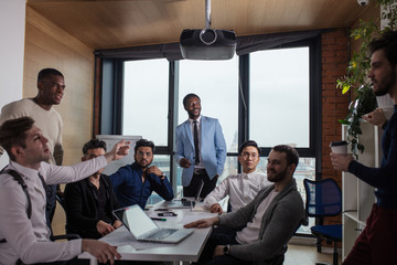 Canvas Print - Businessman in blue formal suit standing and leading business meeting. Male chief executive putting his ideas during presentation in boardroom.