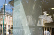 Empty shop window for logo, brand mockup. City street and buildings in window reflection.