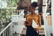 © Yakobchuk Olena - Attractive afro american girl holding smartphone and documents