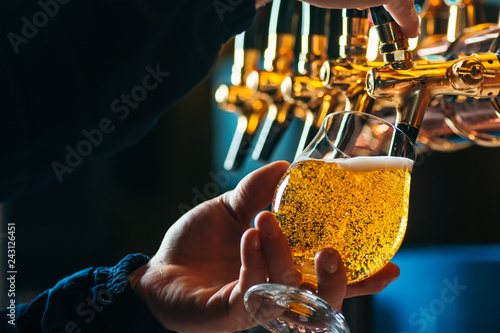 Cuadros en Lienzo Close up of bartender pouring draft beer in glass
