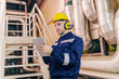 © dusanpetkovic1 - Young Caucasian man in protective suit using tablet while standing in heating plant.