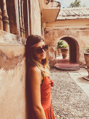 Wall Mural - Beautiful attractive woman posing near old building.