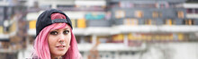 Young Alternative Woman With Piercings And Pink Hair In Front Of Defocused Housing Estate In The Background                      
