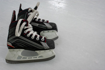 Wall Mural - Kid’s Hockey skates lying over ice rink with copy space 