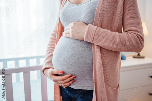 Cuadros en Lienzo Pregnant young woman holding her belly