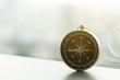© ZhouEka - Single manual compass and light flare with blur city background.
