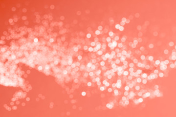 Blury glitter on coral background.