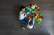 © karrastock - Two happy baby playing with toy blocks.