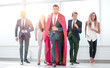 © ASDF - businessman superhero and his business team are stepping togethe