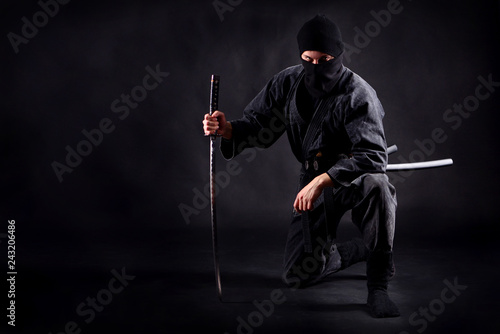 фотографія Ninja samurai crouched on one leg  and propped on a sword