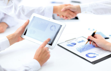 close up.businessman using a digital tablet to calculate the fin