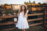 Fototapeta Londyn - The girl in the white dress on the farm.