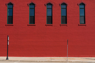 Wall Mural - Red painted brick wall with windows.