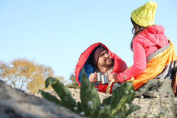 Wall Mural - Couple of campers in sleeping bags sitting on rock. Space for text