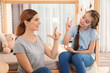 © New Africa - Hearing impaired mother and her child talking with help of sign language indoors