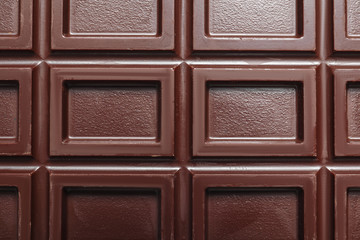 Tasty dark chocolate bar as background, top view