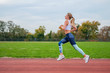 © Dmytro Flisak - Athletic woman running on athletics race track.