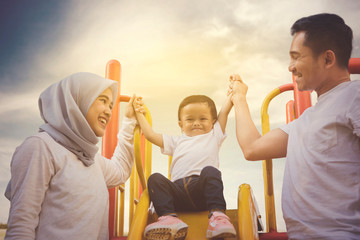 Sticker - Happy baby girl with her parents in the playground