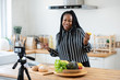Happy african american woman vlogger broadcasting cooking live video at home