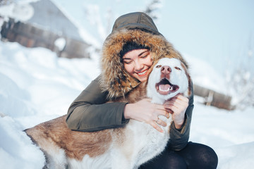 A young woman play with the dog red husky