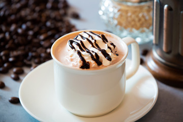 cup of coffee with whipped cream and beans