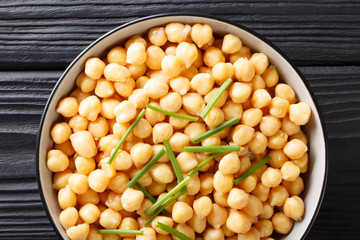 Canvas Print - Organic snack boiled chickpeas close-up in a black bowl. horizontal top view