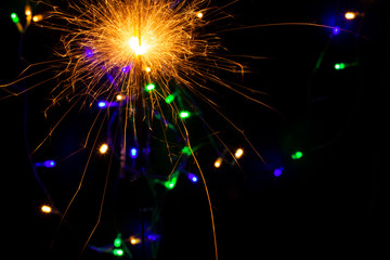 festive background with sparkler and new year lights closeup