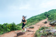Sporty Young Woman In Black Sportswear Trail Running On Mountain Nature Path. Fit Girl Jogging Downhill Rocky Track.