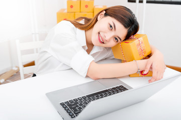 Wall Mural - women working laptop computer from home on wooden floor with postal parcel, Selling online ideas concept, Women selling online start up small business owner working with using laptop