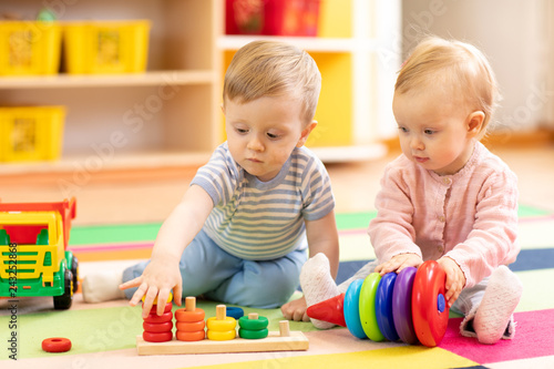Fotografía Preschool boy and girl playing on floor with educational toys