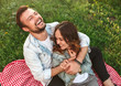 Young man hugging girlfriend and laughing in countryside