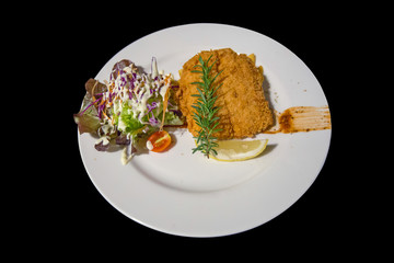 Steak fish on white plate with isolated black background