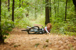 © pressmaster - Young sportswoman fell off her bicycle and hurt her leg on forest path during morning ride