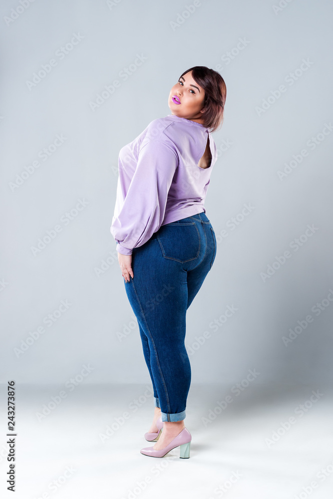Plus size fashion model in casual clothes, fat woman on gray background - obrazy, fototapety, plakaty 