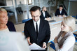 © pressmaster - One of confident economists reading financial document to his female colleagues at working meeting before conference