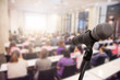 © nattanan - Microphone over the blurred business people forum Meeting or Conference Training Learning Coaching Room Concept, Blurred background.