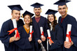 © Syda Productions - education, graduation and people concept - group of happy graduate students in mortar boards and bachelor gowns with diplomas taking picture by slfie stick over white background