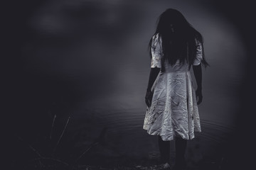 Portrait of asian woman make up ghost face at the swamp,Horror scene,Scary background,Halloween poster,Thailand people