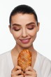 © Andriy Goncharenko - Portrait of a smiling beautiful woman with a sesame bun in her hand