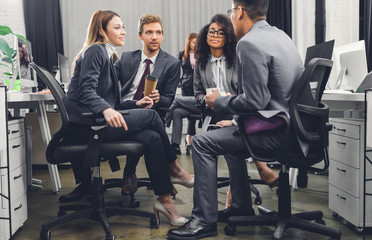 Wall Mural - professional young multiracial business team in formal wear sitting together and discussing work in office