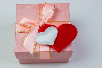 A gift in a beautiful box and hearts are red and white. Valentine's Day, International Women's Day.