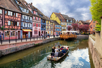 colmar, france. boat with tourists on canal in little venice (la petite venise) area