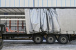 A semi-trailer with an exposed tarpaulin during unloading. Transport and unloading.
