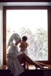 © saulich84 - mom and son sitting by the window on a wide windowsill