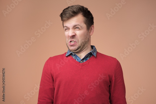 Fotografie, Tablou Shocked young man looking at something unpleasant and bad