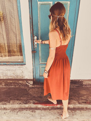 Wall Mural - Beautiful attractive woman posing in front of blue wooden door.