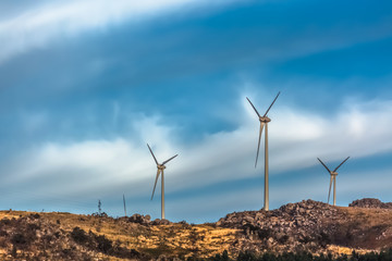 Wall Mural - View of a wind turbines on top of mountains, dramatic sunset sky