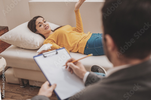 Fotografia Dark-haired woman feeling at a loss while listening to psychologist