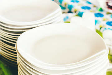 Two piles of elegant white plates