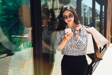 woman shopping bags rely against display window